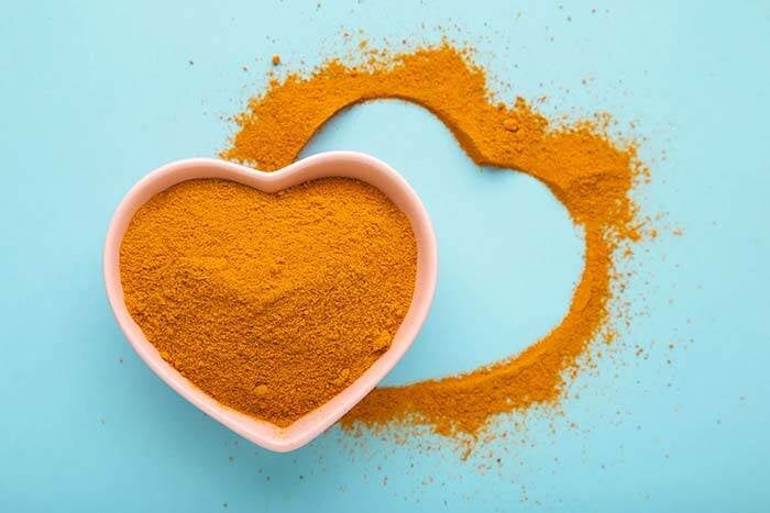 Turmeric powder in a heart shape to symbolize health