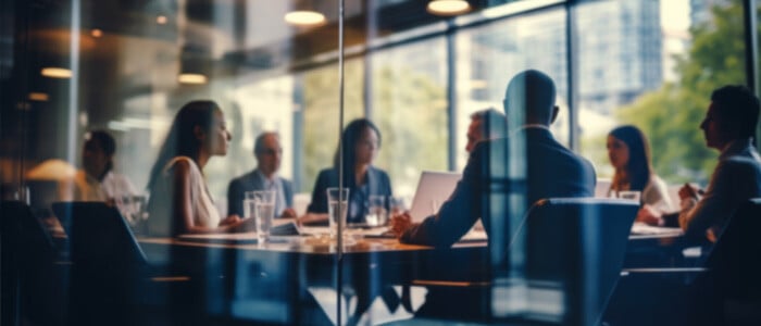 corporate meeting room setting with multiple professionals around a table