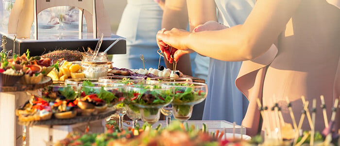a buffet table displaying a variety of food dishes and drinks, elegantly arranged for guests to serve themselves