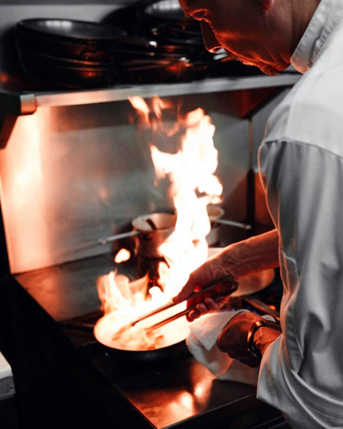 Chef working with flaming hot pan