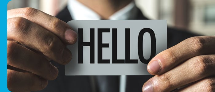 Student holding "hello" badge