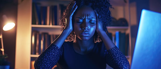 Stressed person holding her head between her hands