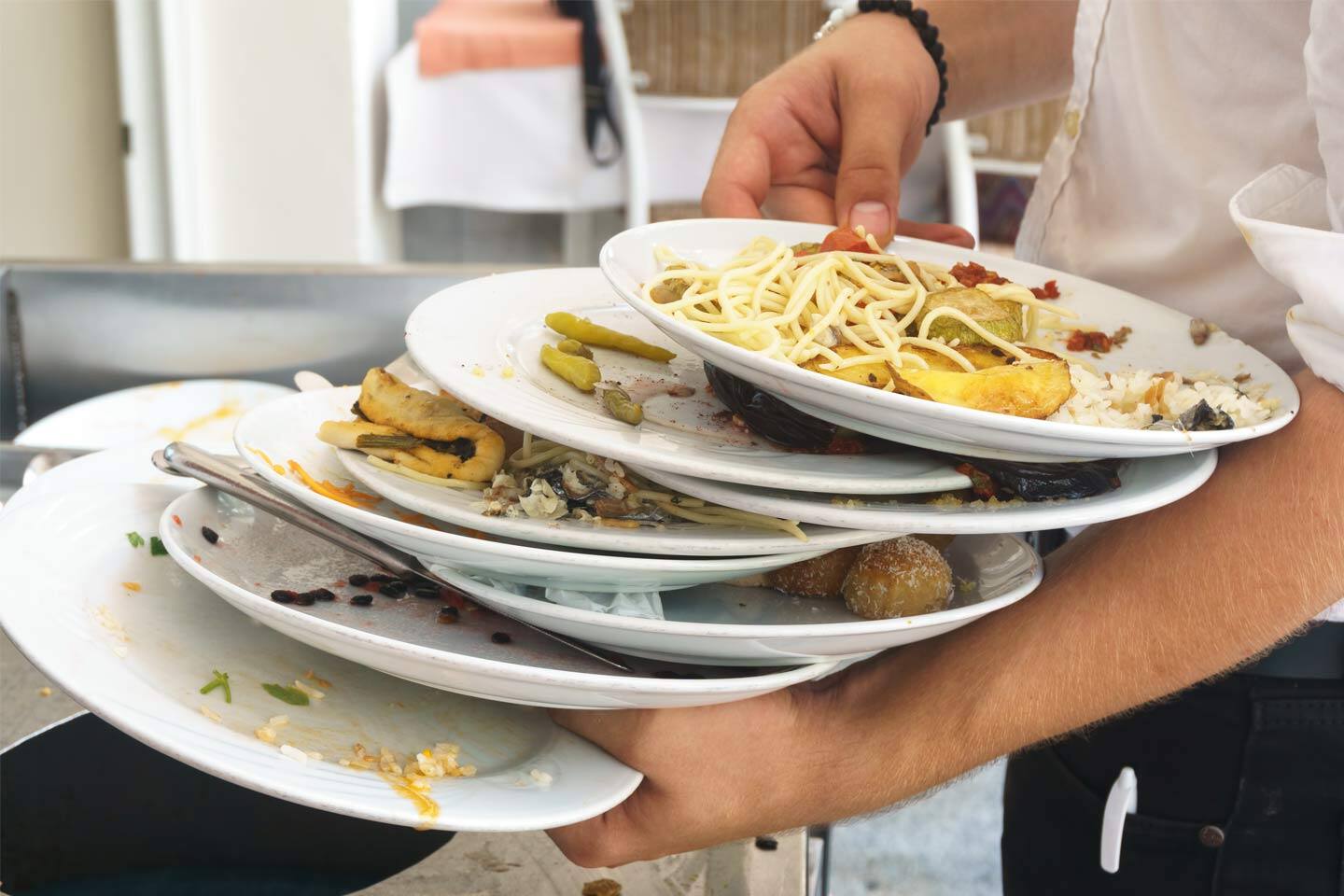 a waiter balancing a stack of plates filled with food